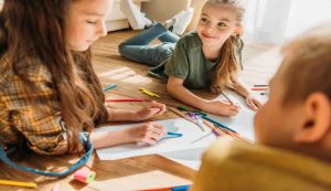 Bambini che insieme colorano sorridenti