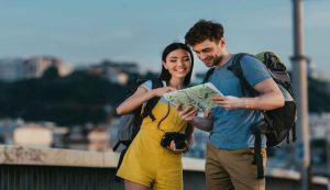 Coppia felice che si orienta con una mappa durante un viaggio