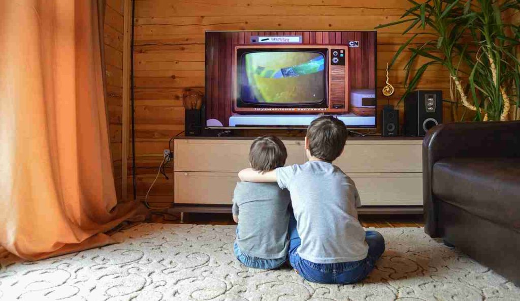 Illustrazione di due bambini mentre guardano la tv (Pixabay FOTO) - www.financecue.it